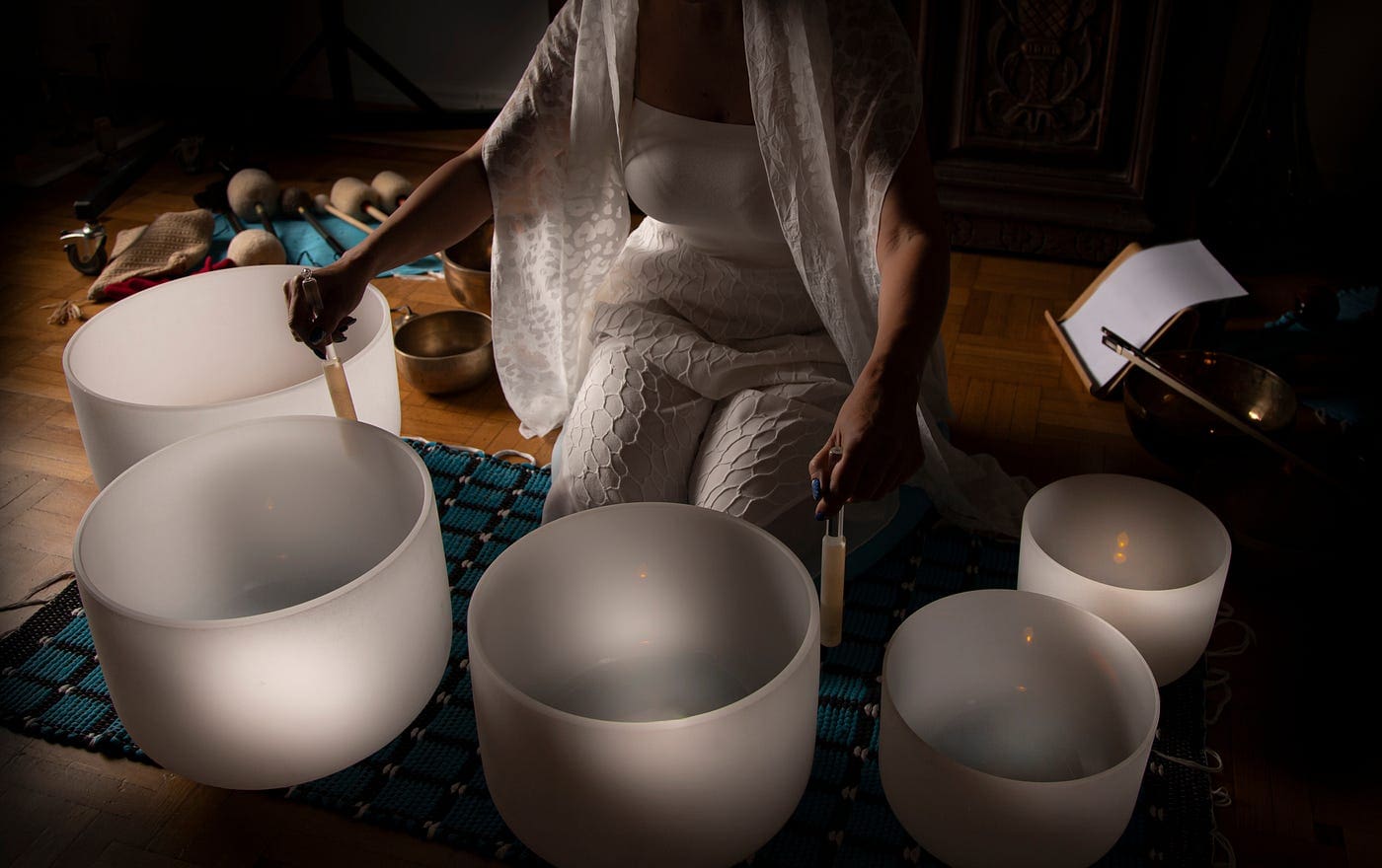 A woman in white is playing with some bowls