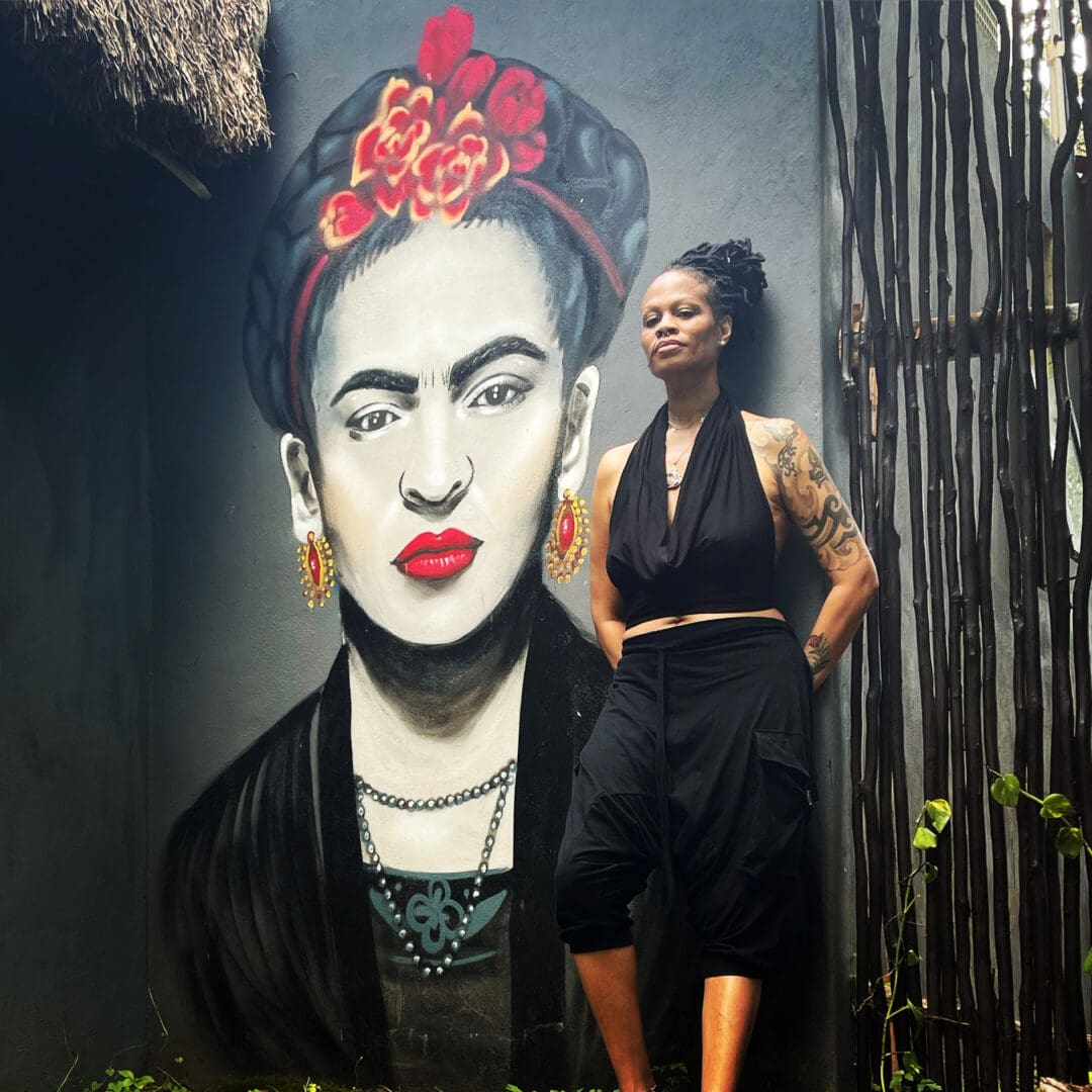 A woman standing in front of a painting.